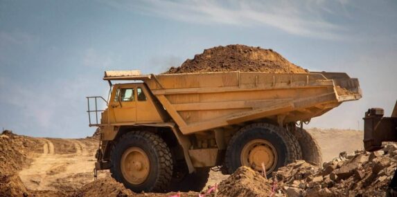 very large haul dump truck filled with dirt at a construction site