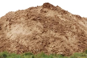 large pile of construction sand on forest grassy site in SW Florida