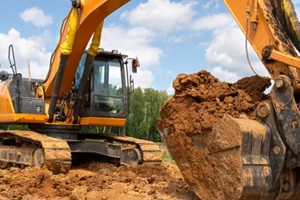 Fort Myers excavator works in the field against the background of the forest