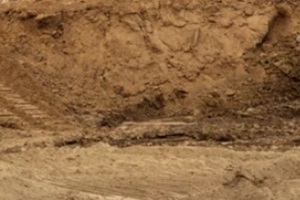 isolate mounds of sand and concrete debris that have been excavated and poured together with backhoe wheels to prepare materials for filling and repairing roads