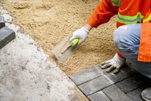 Punta Gorda, FL Worker laying brick pavers on the sidewalk