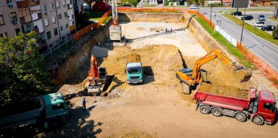 ariel view excavator is loading fill dirt into a truck with ground on building site in central FL