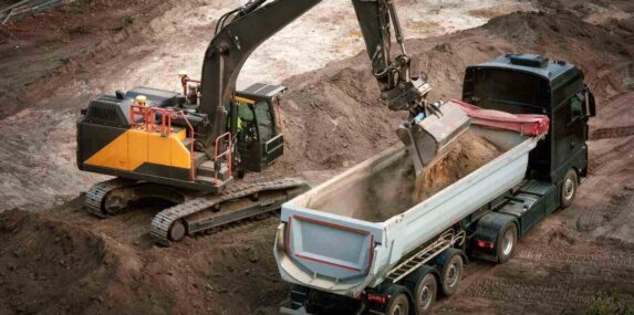 excavator loading fill dirt into a truck in central Florida