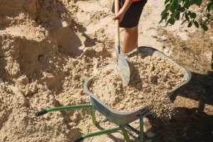 Worker Filling Wheelbarrow with Clean Fill Dirt from Punta Gorda, FL quarry