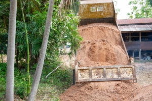 Dump Truck Unloading Fill Dirt on Ground