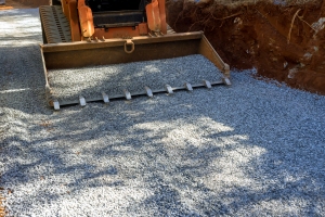 Loader Excavator Spreading Crushed Stone for Commercial Driveway