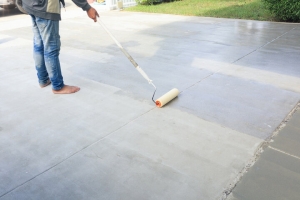 Worker Finishing Crack Repair on Driveway